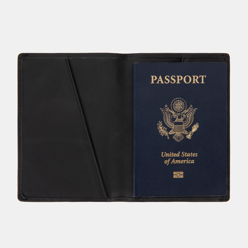 The SLNT RFID Passport Wallet by SLNT holds a U.S. passport with a navy blue cover, shown open against a white background.