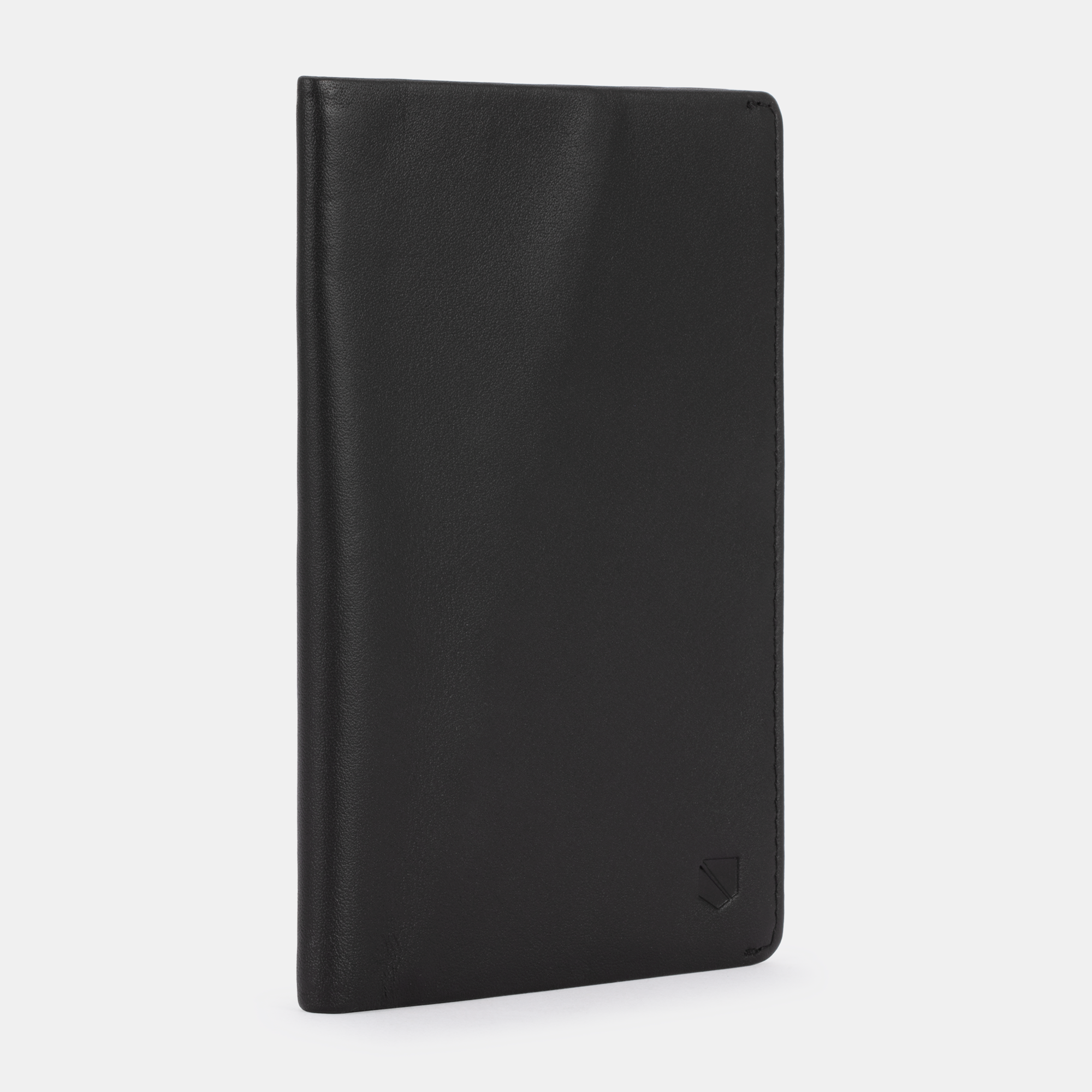 The SLNT RFID Passport Wallet by SLNT, a closed black leather holder, stands upright against a plain white background with a small embossed logo in the bottom right corner.